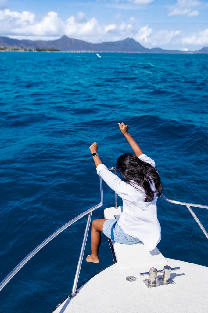 Guest on the bow of a private Hermes Cruise boat looking out over the ocean